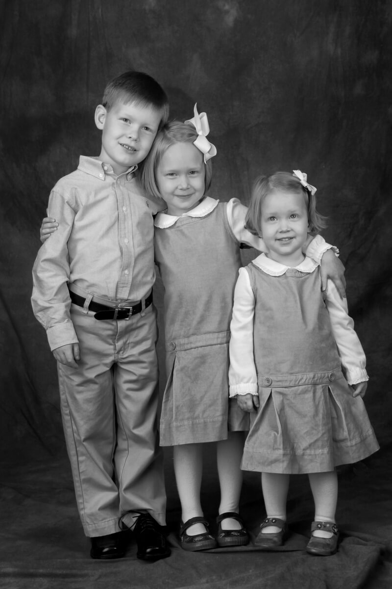 black and white portrait of three siblings