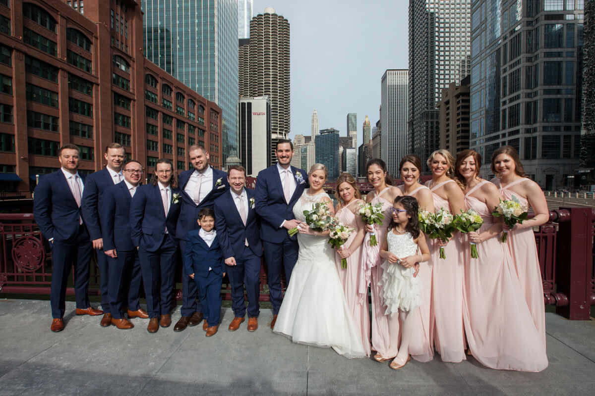 Large wedding party poses on a Chicago River Bridge