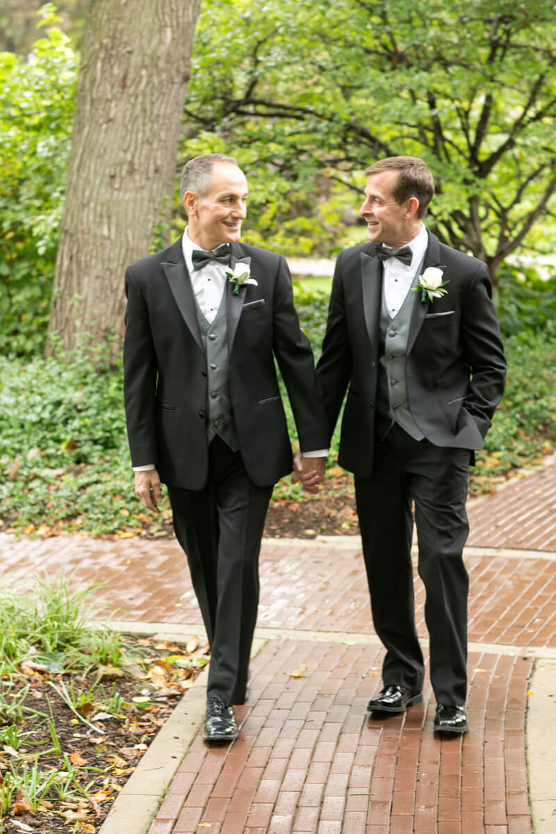 Grooms stroll down path during portrait session