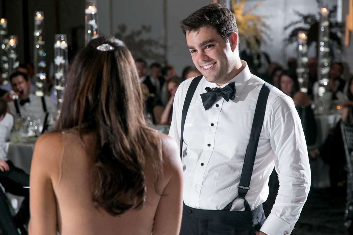 Groom smiles during toast by bride
